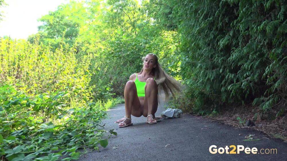 Blonde teen Daisy Lee takes a piss on a paved path through the woods - #13