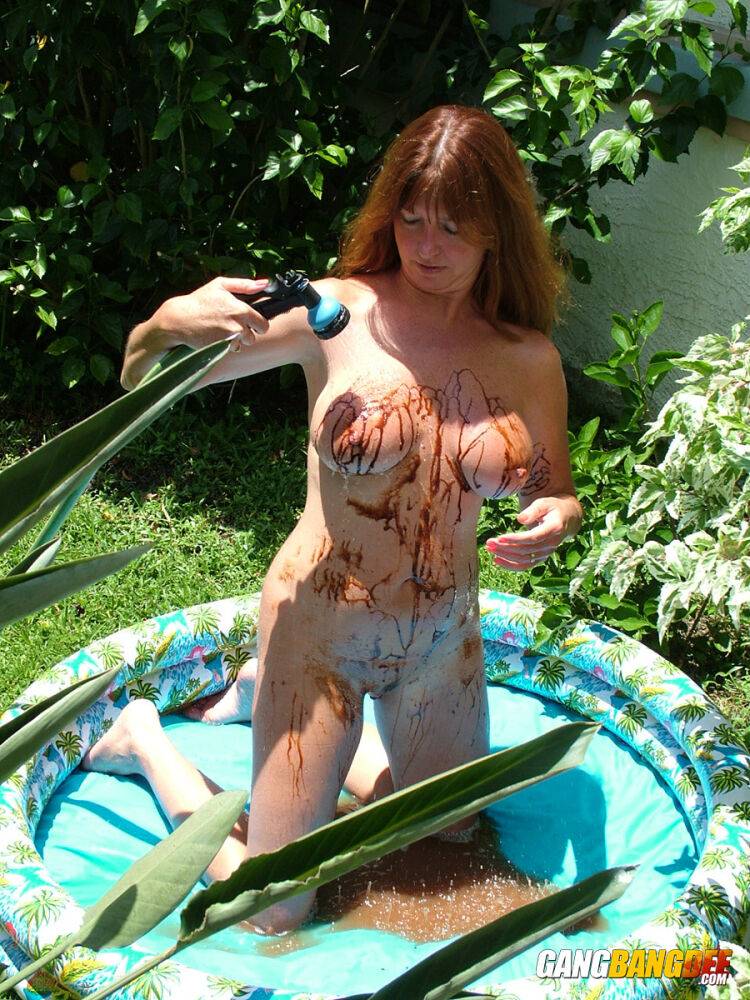 Busty older lady Dee Delmar douses herself in chocolate syrup in a wading pool - #5