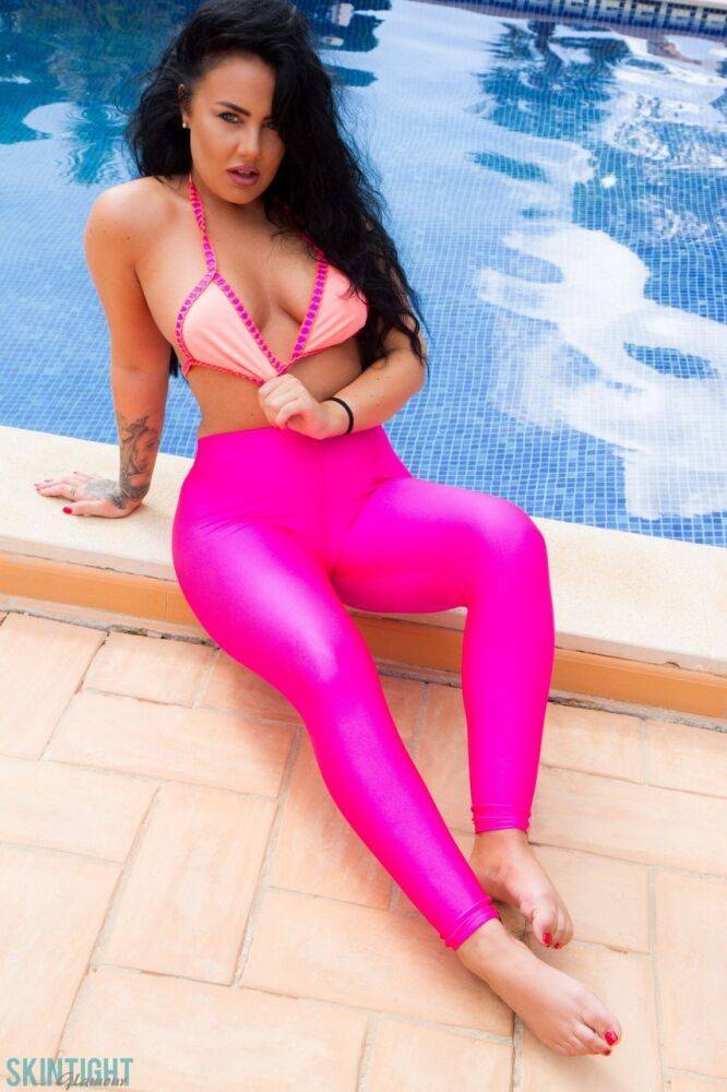 Glamour model Olivia Paige slips pink leggings over bikini bottoms by a pool - #8