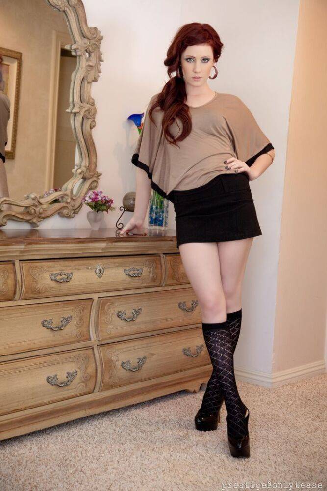 Pale redhead Elle Alexandra strips to knee sock and a thong afore a mirror | Photo: 1350637