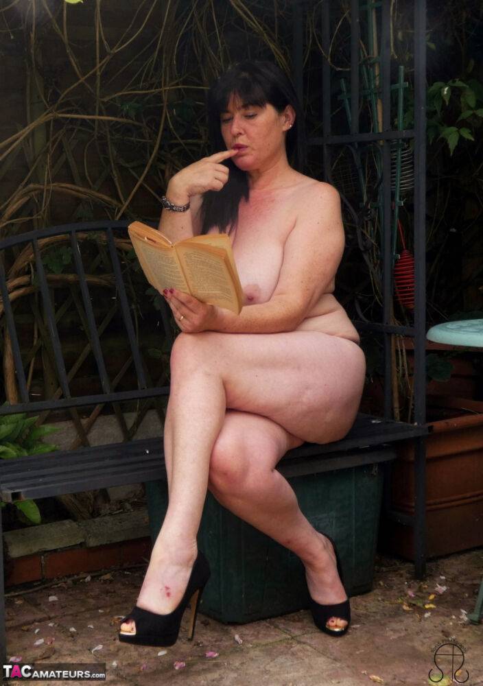 Busty British woman Juicey Janey masturbates while reading a book on a patio - #11