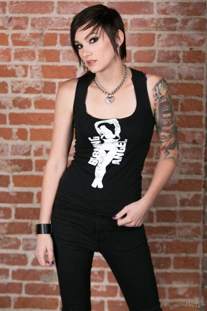 Punk girl Nikki Hearts frees her tattooed body of clothes afore a brick wall - #10