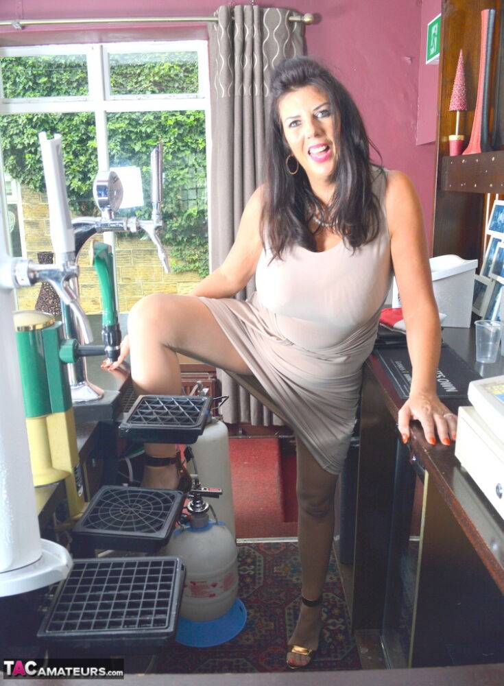 Brunette female Lu Lu Lush slips pantyhose over her ass atop a bar - #2
