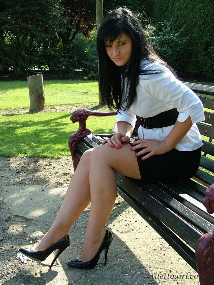 Dark haired female displays some leg and her stiletto heels on a park bench - #10