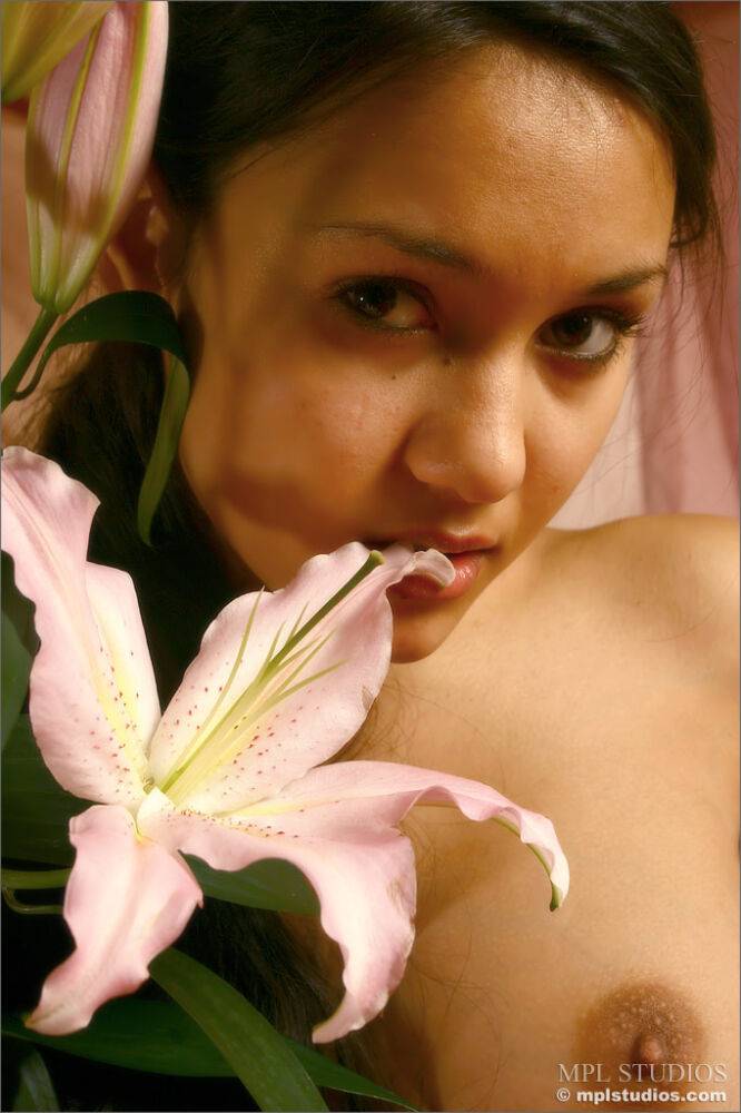 Pretty girl holds a long-stemmed flower while modelling in the nude - #5