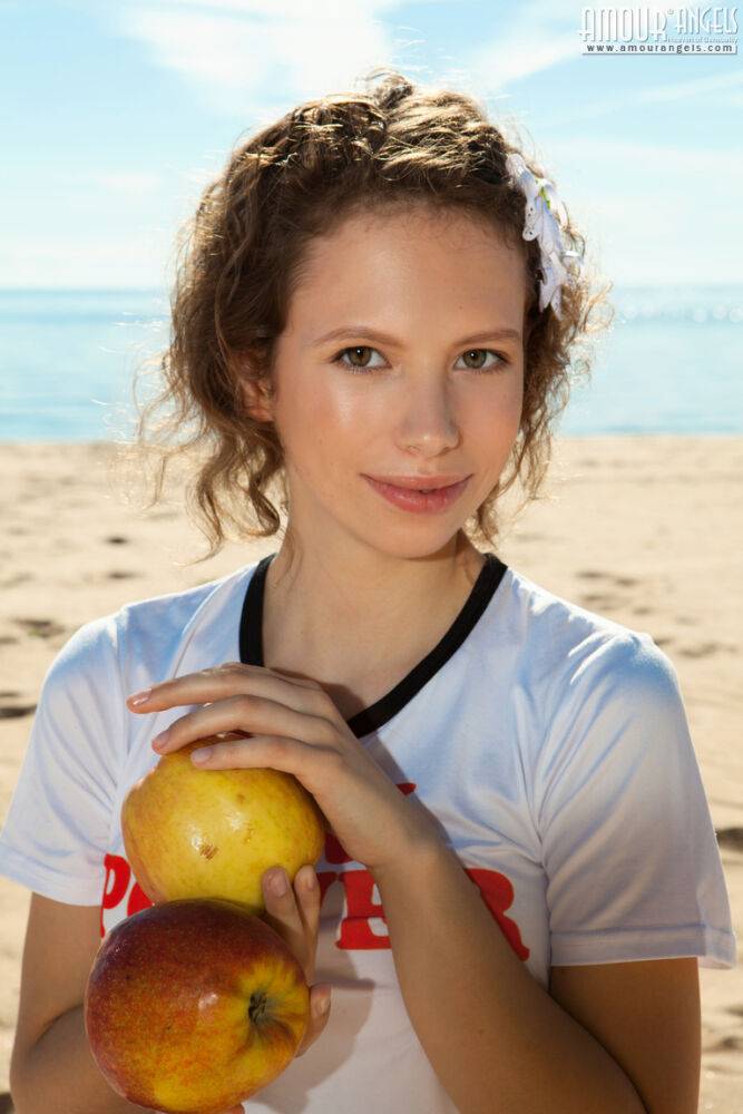 Young looking girl Amore gets totally naked on a sandy beach - #10