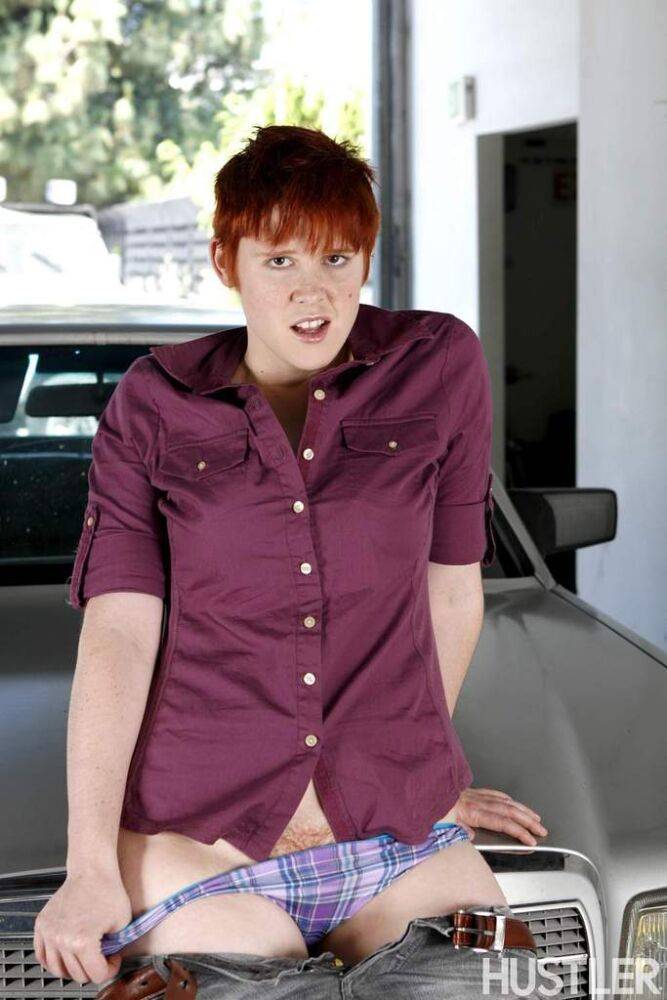 Short haired redhead Lily Cade strips naked atop a car in a garage - #8