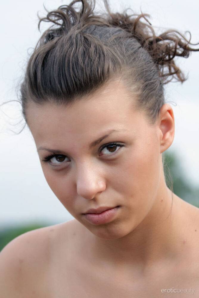 Brunette teen crosses bare legs while stripping to heels overlooking a river - #11