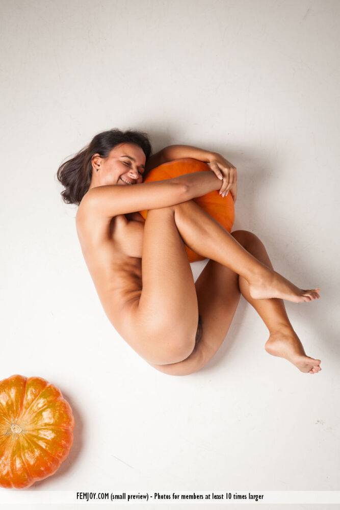 Naked brunette teen with big naturals and a trimmed bush models among pumpkins - #16