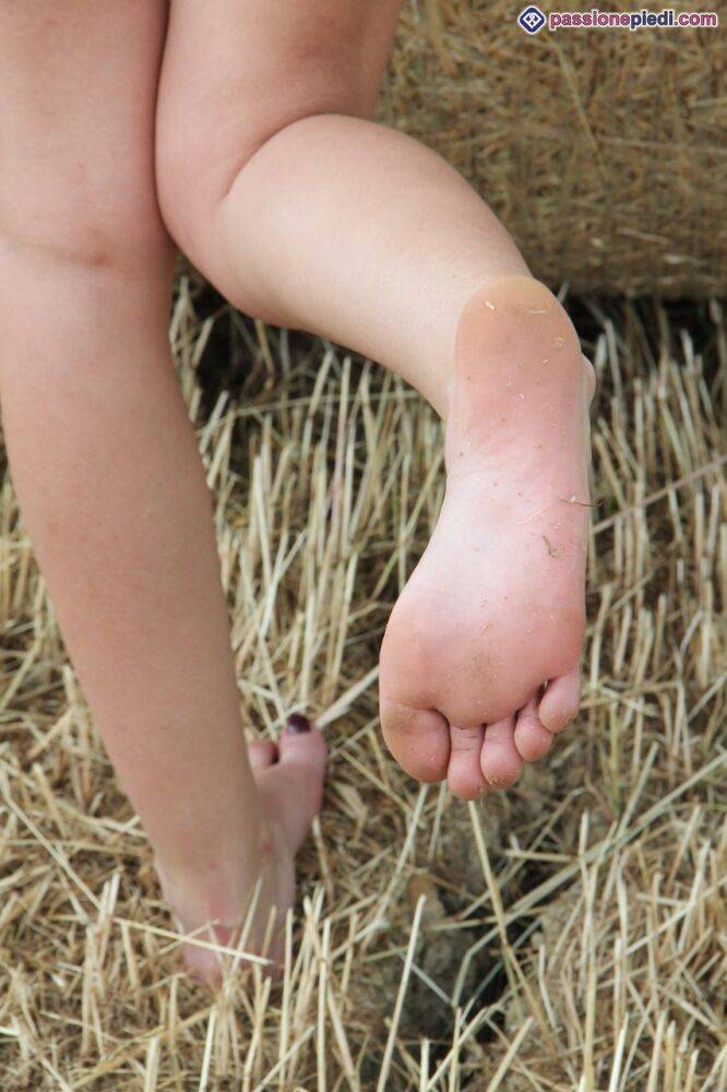 Inked redhead Thena puts her bare feet on display next to a round bale of hay - #3