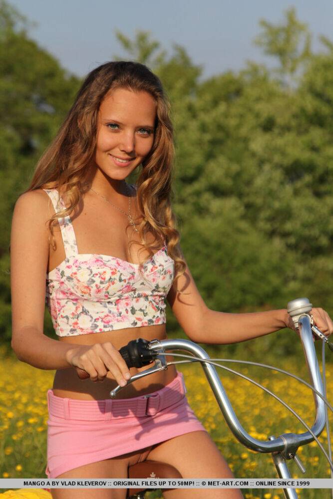 Cute teen Mango A gets naked in a field of yellows flowers during a bike ride - #1