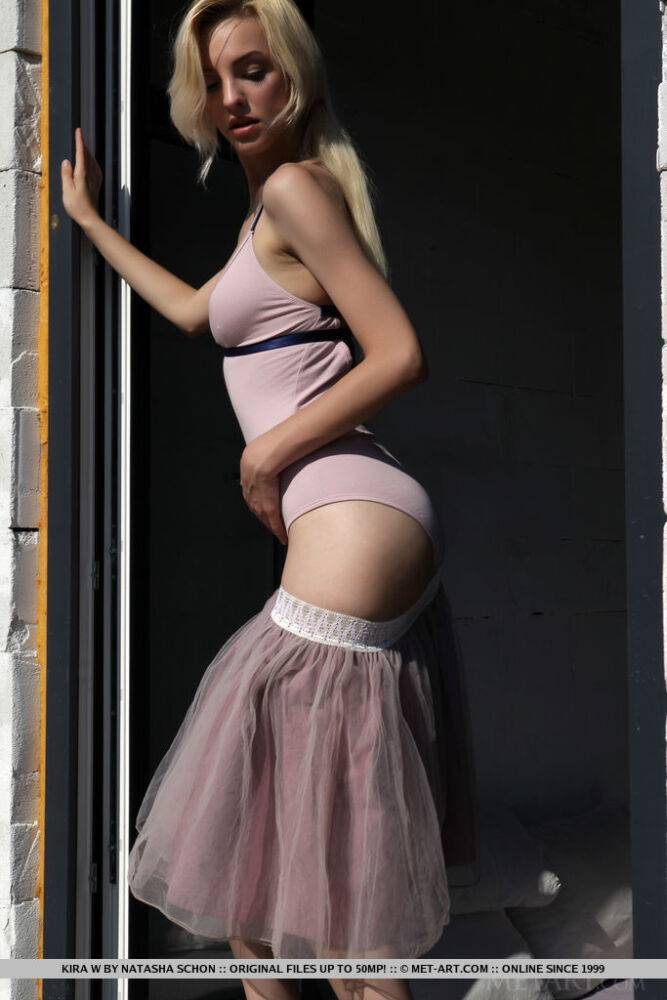 Blonde teen Kira W gets naked in ankle strap heels against a cinder block wall - #14