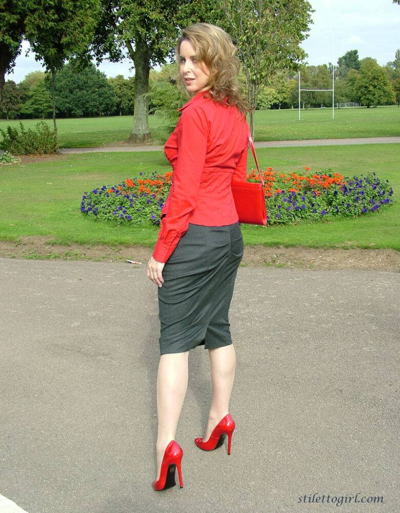 Mature woman crosses her hose covered legs in a long skirt and red pumps - #8