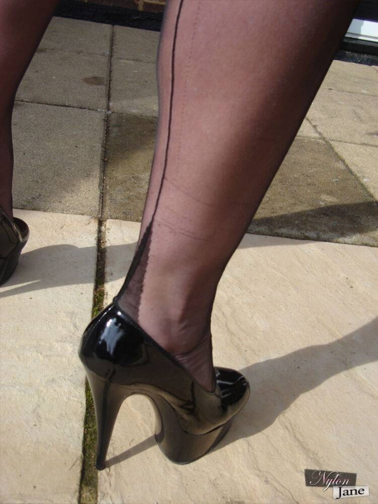 Mature woman Nylon Jane models on her patio in hosiery and garters plus heels - #9