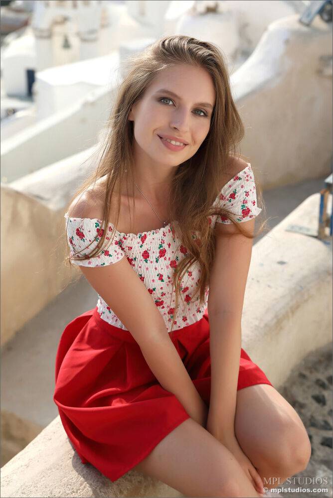 Pretty girl models fully clothed in a red skirt while on vacation | Photo: 2657290