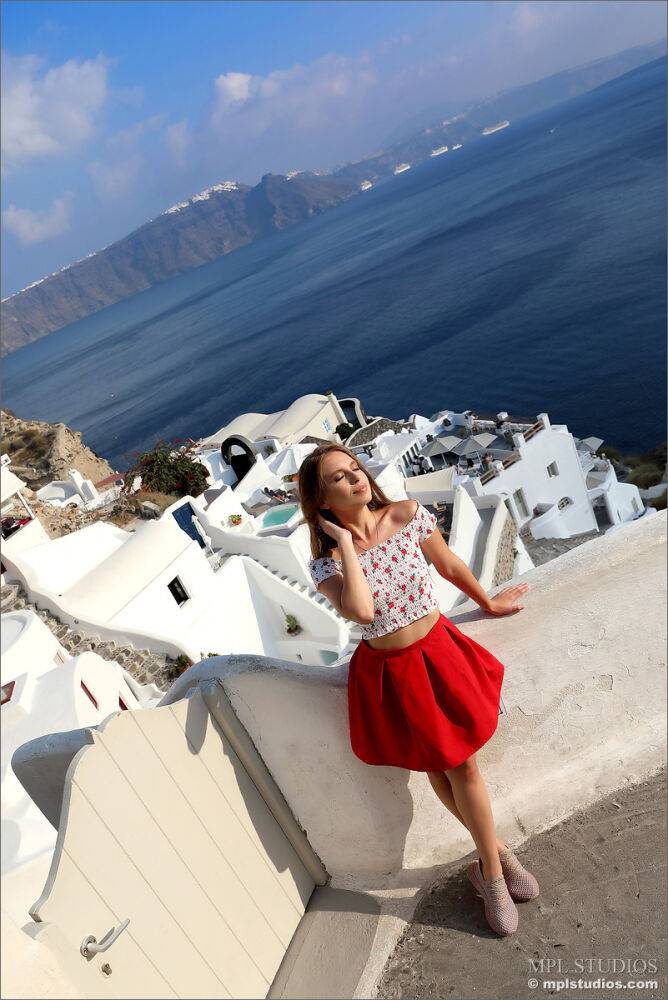 Pretty girl models fully clothed in a red skirt while on vacation | Photo: 2657261