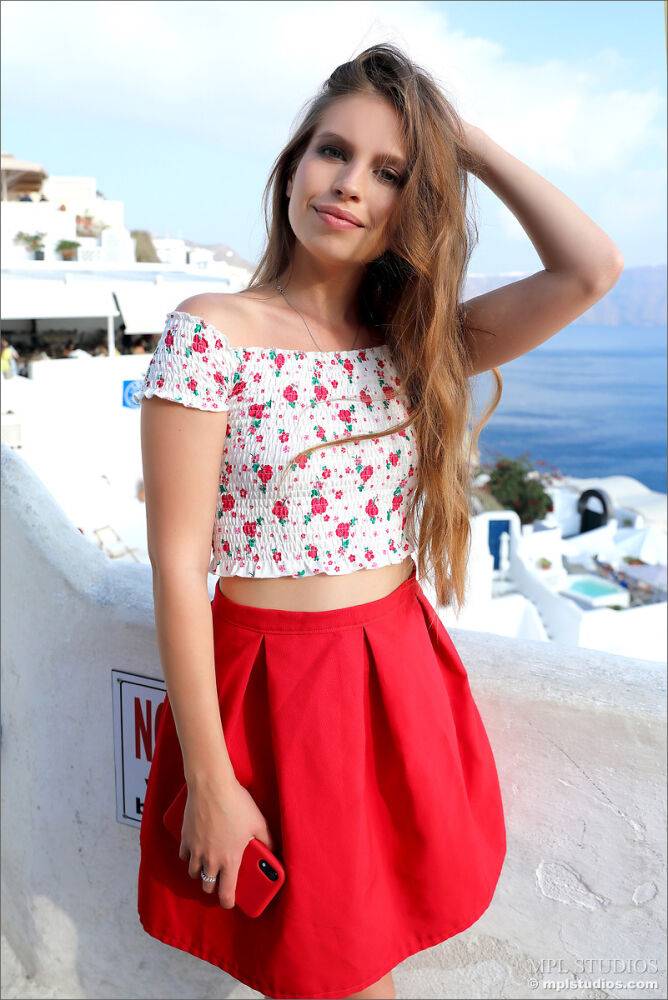 Pretty girl models fully clothed in a red skirt while on vacation | Photo: 2657268