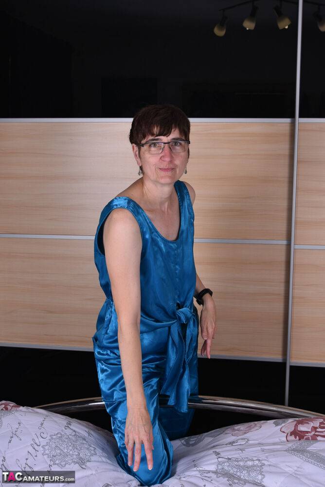 Amateur woman models satin evening wear on a bed with her glasses on - #10