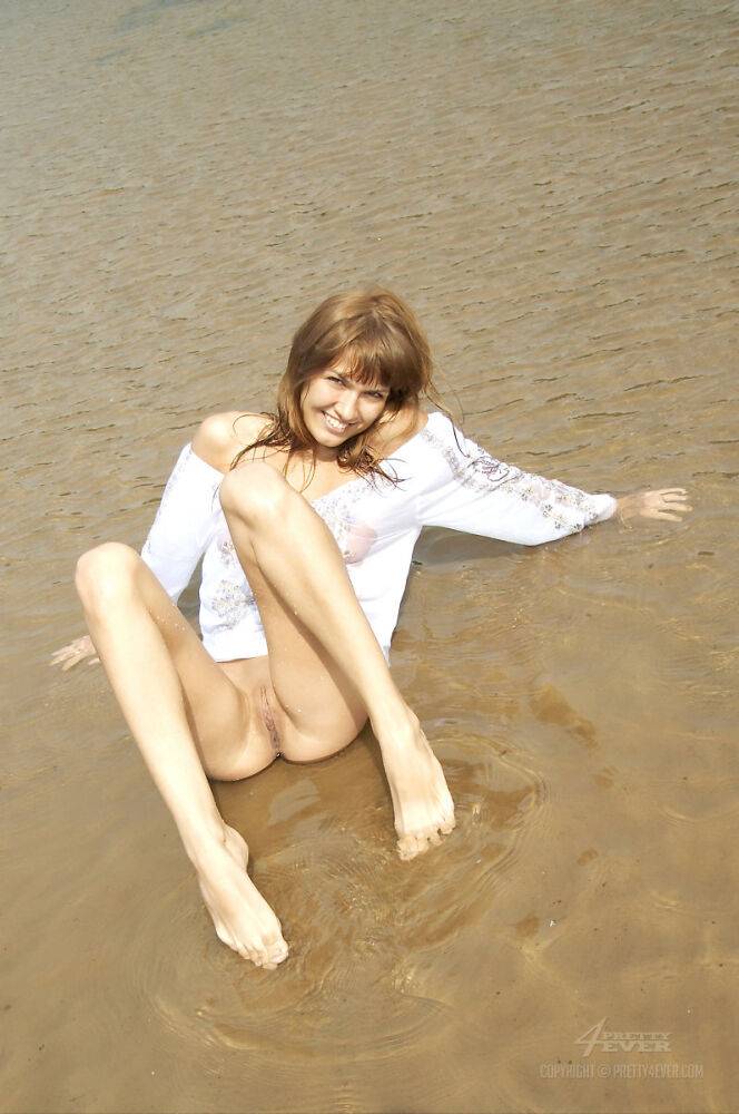 Young beauty Alena models in shallow water during solo action - #2