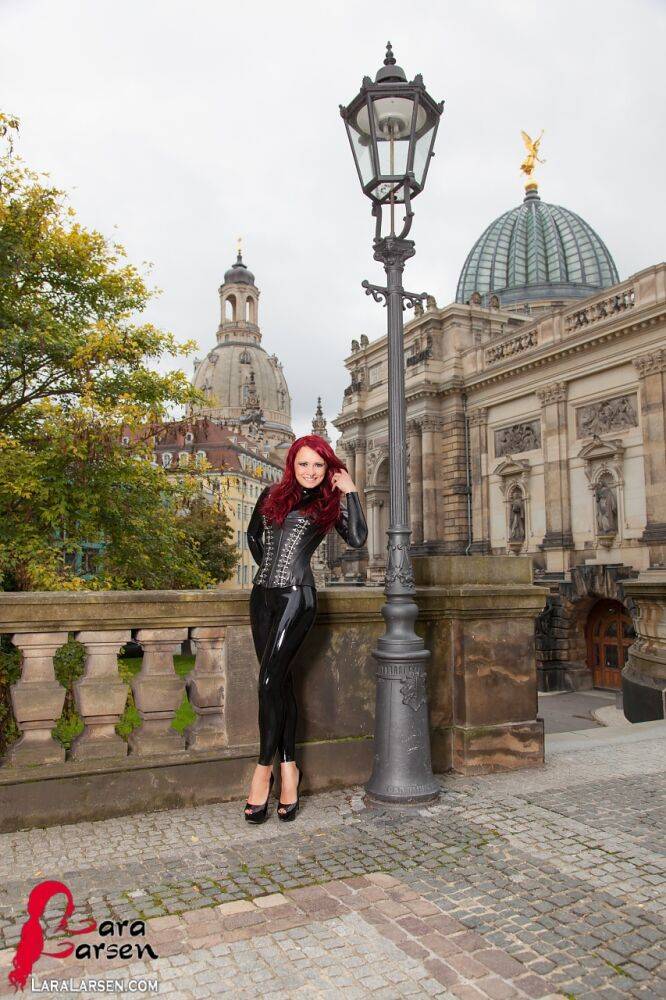 Clothed redhead Lara Larsen models latex attire and high heels in public - #1