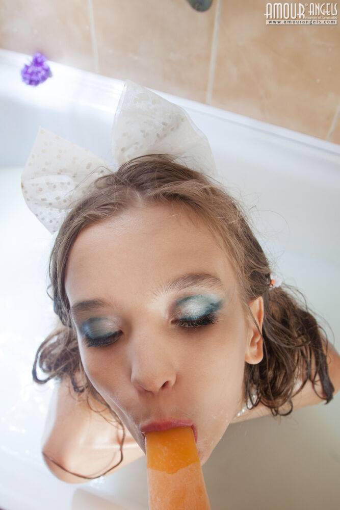 Tiny teen girl Alisabelle pours milk over her naked body while taking a bath | Photo: 2803600