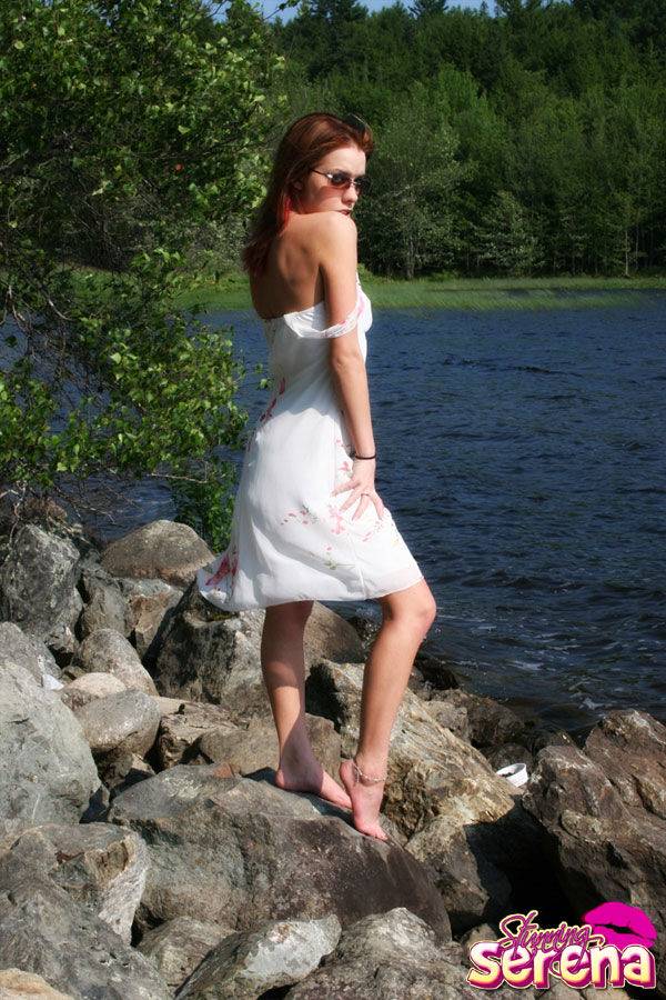 Young redhead Stunning Serena slips out of her dress on waterside rocks - #5