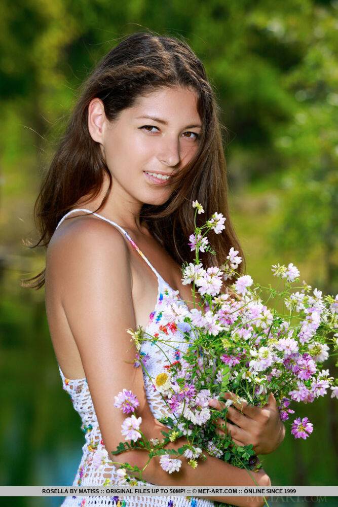 Glamour model Rosella holds wildflowers before posing nude by a pond - #12