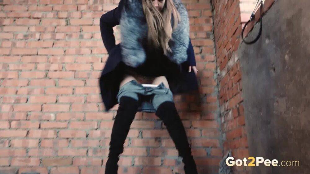 Distressed girl squats for an outdoor piss while wearing a heavy winter coat - #3