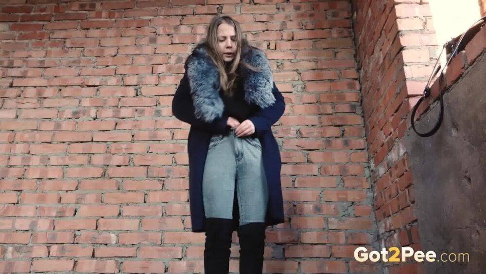 Distressed girl squats for an outdoor piss while wearing a heavy winter coat - #8