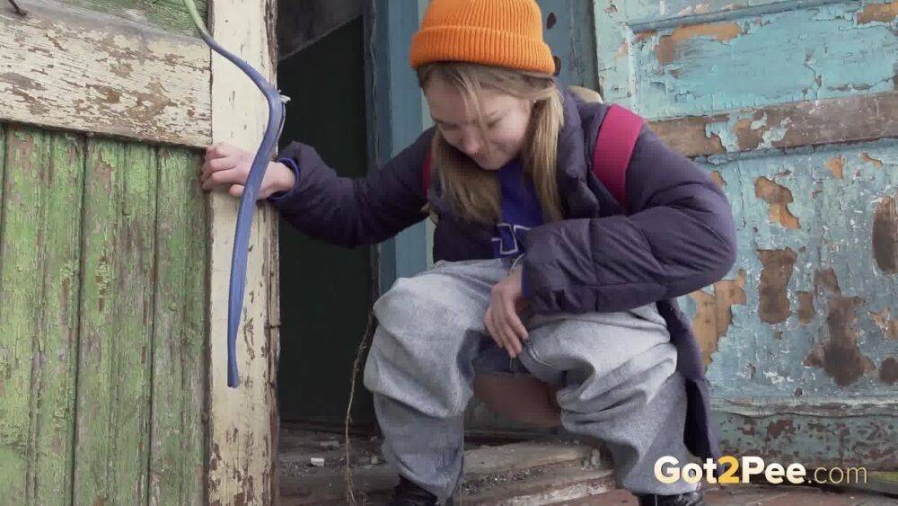 Cute girl pulls down jeans for an urgent piss on the steps of an old building - #3