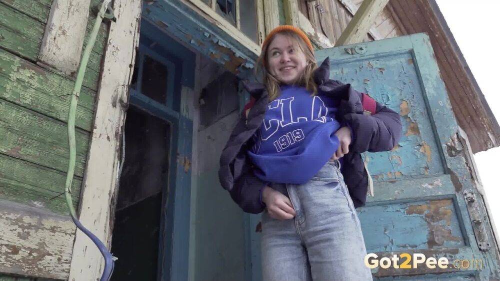 Cute girl pulls down jeans for an urgent piss on the steps of an old building - #15