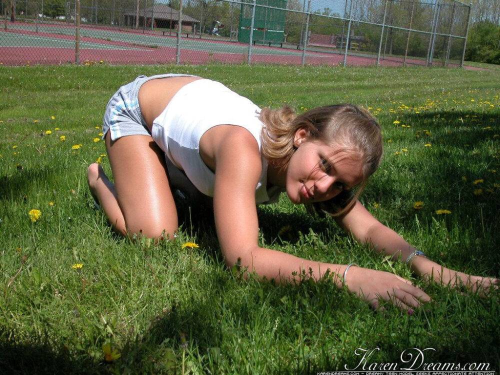 Cute blonde teen Karen lounging on the grass teasing non nude in shorts - #2