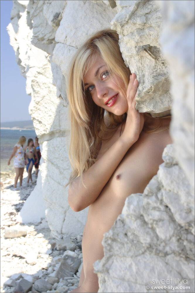 Sweet teen girl takes off her bikini for nude poses against white cliffs - #6