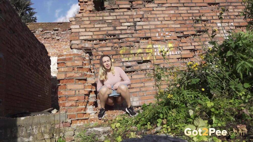 White girl ducks behind an old building to take an urgent piss - #9