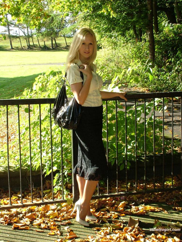 Clothed blonde Iona shows off her white stilettos in a long skirt by a park - #3