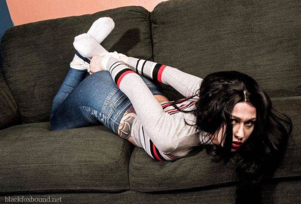 Dark haired chick is hogtied on a couch while closed in jeans and white socks - #6