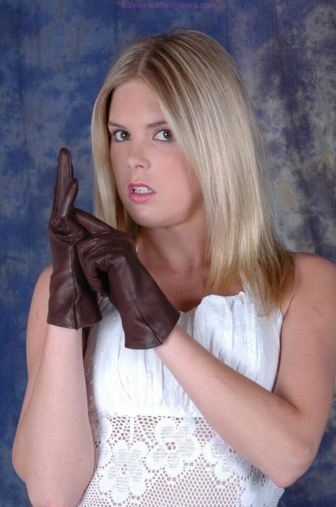 Blonde female pulls on brown leather gloves while wearing a white dress - #3