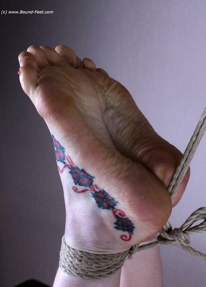 Naked white girl sports tattooed feet while suspended in midair by ropes - #12