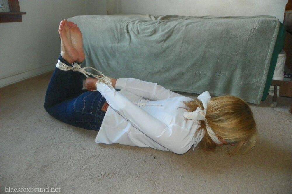 Blonde woman is cleave gagged and hogtied in a white blouse and blue jeans - #2