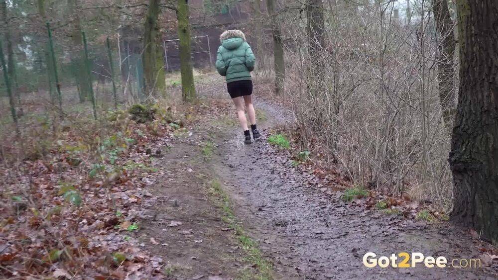 White girl Ali Bordeaux squats for a piss against a fence in a winter coat - #14