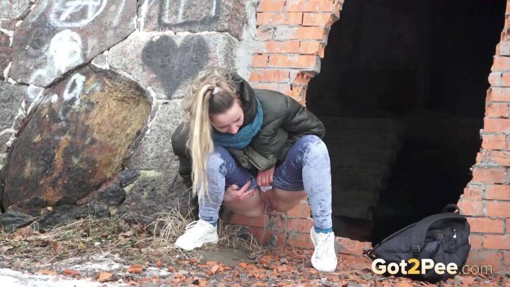 White girl pulls down her jeans for a badly needed pee on snow-covered ground - #1