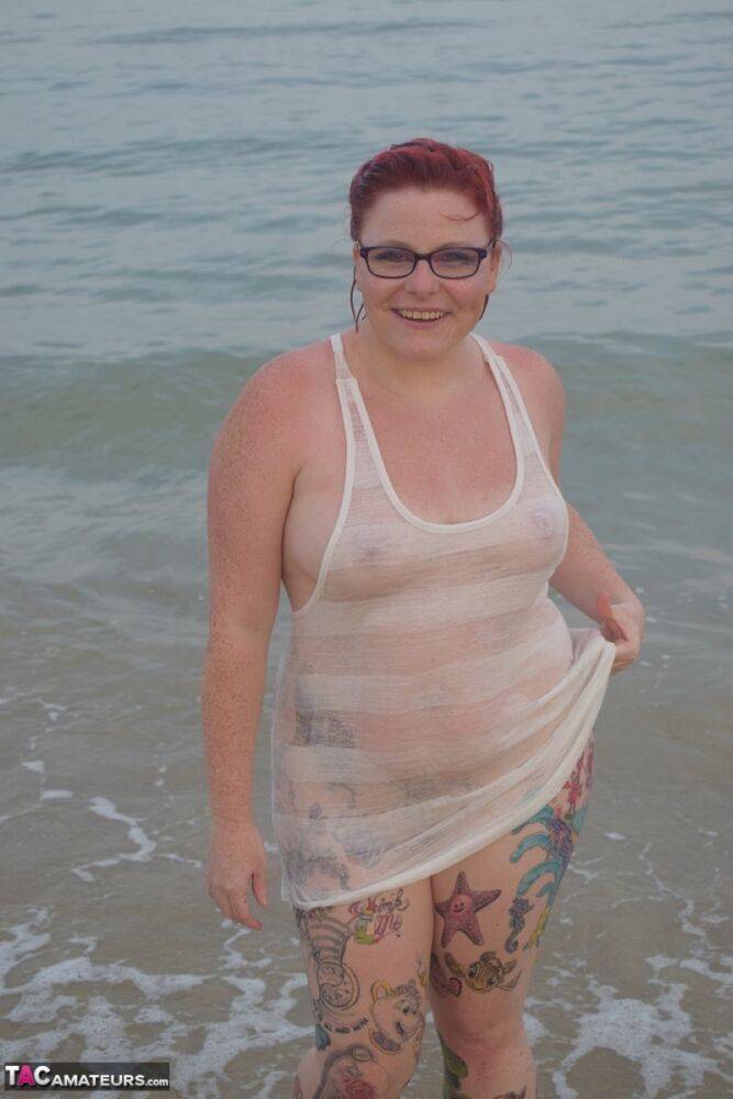 Tattooed redhead poses nude on a beach before masturbating on a toilet seat - #10