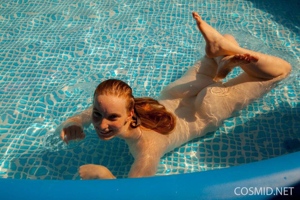 Natural redhead Julia Fleming frees her big natural tits in above ground pool - #13