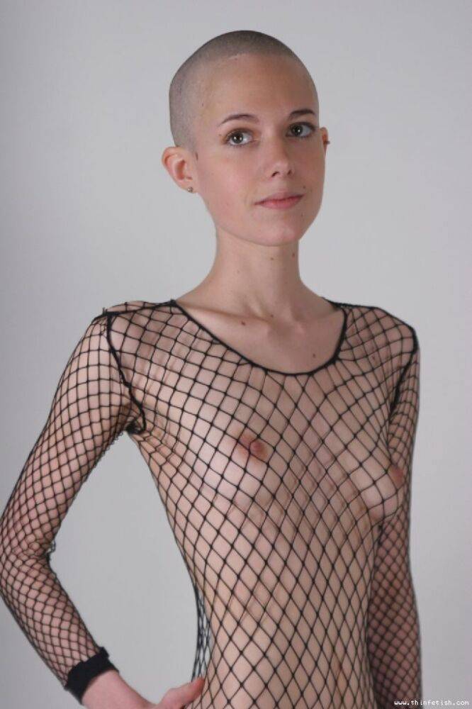 Solo model with a shaved head poses in a fishnet bodystocking - #3