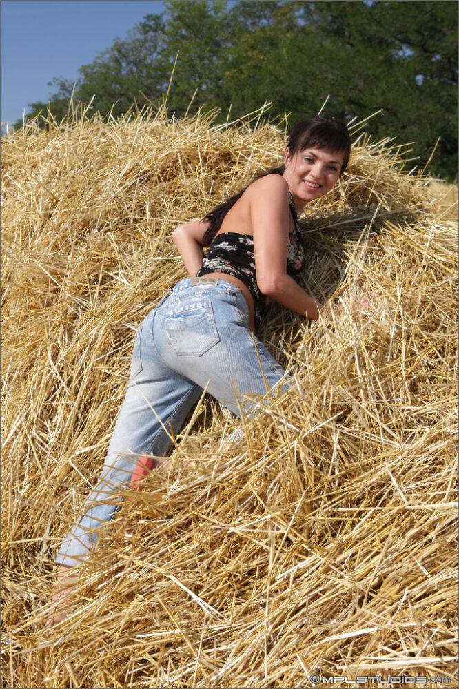 Solo girl with black hair reveals her big natural tits in a pile of straw - #12