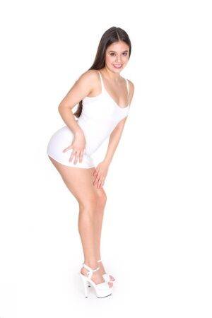Beautiful Latina teen Lucy Doll gets naked by herself in white heels on picsofsex.com