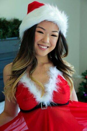 Cute Asian teen Lulu Chu wears Xmas lingerie during sex on a bed on picsofsex.com