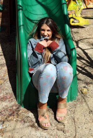 Busty amateur female August Ames spreading pussy lips apart on swing set on picsofsex.com