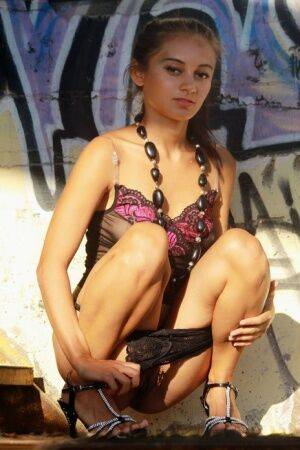 Petite teen Sima B showcases her pussy afore a backdrop of graffiti on picsofsex.com