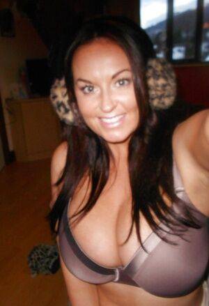 Buxom brunette babe Sarah Nicole Randall posing topless with ear muffs on picsofsex.com